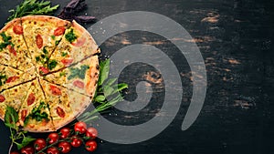 Pizza with cherry tomatoes, suluguni cheese and basil. Italian cuisine. On a wooden background. Free space for text.