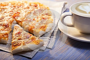 Pizza and Coffee on wooden table, cup of cappuccino.