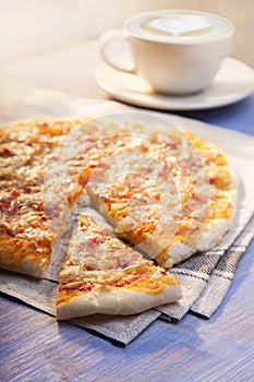 Pizza and Coffee on wooden table, cup of cappuccino.