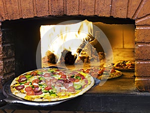 Una grande sfoglia circolare di pasta leggera arrivo fuori da legna bruciando una grande sfoglia circolare di pasta leggera forno 