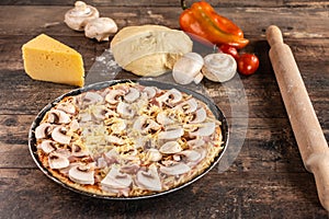 Pizza Cooking Ingredients. Raw homemade pizza on wooden rustic table