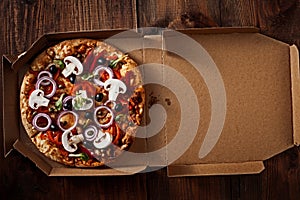 Pizza in the in delivery box on the wood
