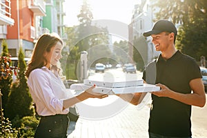 Pizza Delivery. Courier Giving Woman Boxes With Food Outdoors