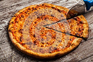 Pizza with different toppings. Italian pizza with different sorts of cheese, vegetables and meat on old wooden background close up