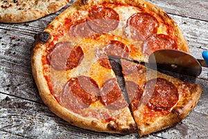 Pizza with different toppings. Italian pizza with different sorts of cheese, vegetables and meat on old wooden background close up