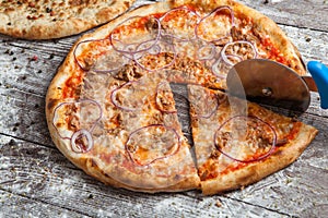 Pizza with different toppings. Italian pizza with different sorts of cheese, vegetables and meat on old wooden background close up