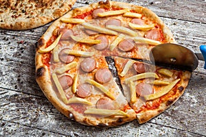 Pizza with different toppings. Italian pizza with different sorts of cheese, vegetables and meat on old wooden background close up