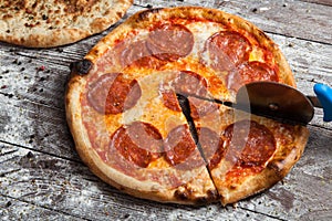 Pizza with different toppings. Italian pizza with different sorts of cheese, vegetables and meat on old wooden background close up