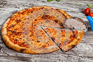 Pizza with different toppings. Italian pizza with different sorts of cheese, vegetables and meat on old wooden background close up