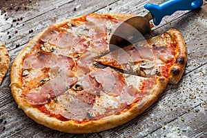 Pizza with different toppings. Italian pizza with different sorts of cheese, vegetables and meat on old wooden background close up