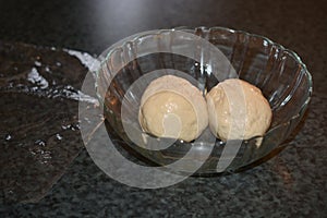 Pizza Dough Split into Two Balls in Glass Bowl