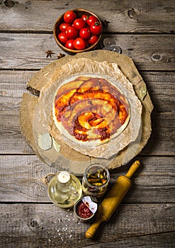 Pizza dough with tomato sauce, tomatoes, and ingrediente rolling pin for pizza.