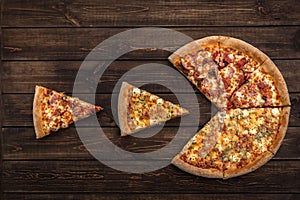 Pizza eating sliced pieces on a dark brown wooden background. Copy space, top view and flat lay concept