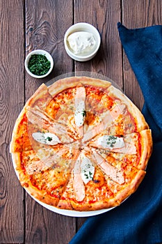 Pizza with fish and cream cheese - Plaisir on a wooden background. photo