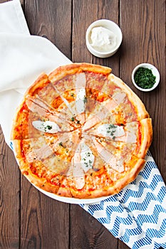 Pizza with fish and cream cheese - Plaisir on a wooden background. photo