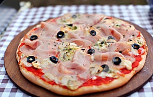 Pizza with fresh ham, mozzarella and black olives