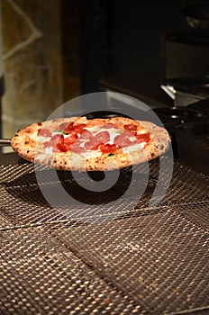 The pizza freshly taken out of the oven was left to cool on a wire rack, and its flavor