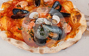 Pizza frutti di mare with shrimps, open clams and mussels and basilic photo