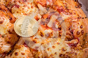 Pizza and golden physical bitcoin, concept of buying pizza with bitcoin