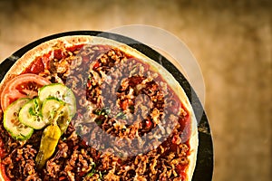 Pizza with ground meat and vegetable toppings