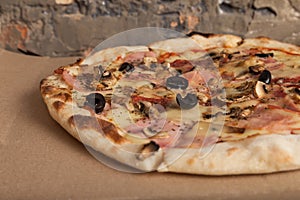 Pizza with ham, black olives, ham, spices. Italian pizza. Home made food. Concept for a tasty and hearty meal, lunch.