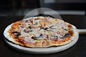 Pizza ham and mushroom on wood