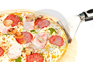 Pizza with ham, mushrooms, salami and pesto sauce