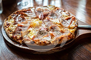 Pizza with ham and mushrooms on a wooden board