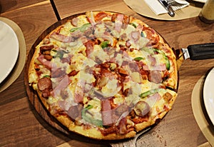 Pizza ham with sausageon dining table