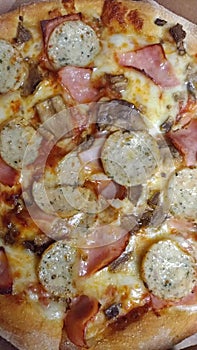 Pizza with ham and white sausages macro
