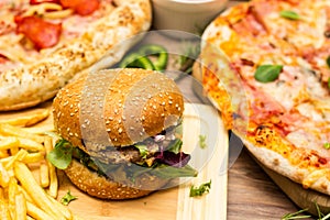 Pizza and hamburger on wooden background