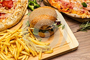 Pizza and hamburger on wooden background