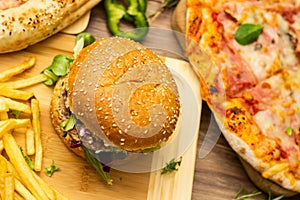 Pizza and hamburger on wooden background