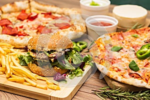 Pizza and hamburger on wooden background