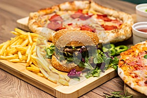 Pizza and hamburger on wooden background