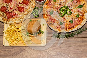 Pizza and hamburger on wooden background