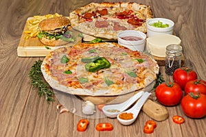 Pizza and hamburger on wooden background