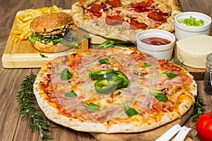 Pizza and hamburger on wooden background