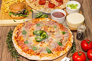 Pizza and hamburger on wooden background