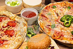 Pizza and hamburger on wooden background