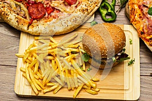 Pizza and hamburger on wooden background