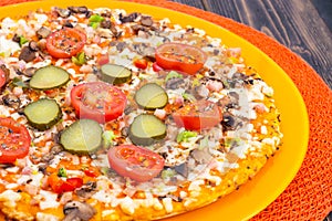 Pizza hommemade on orange plate.