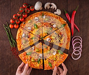 Pizza with ingredients cherry tomatoes mushrooms hot peppers rosemary onion paprika on a wooden table