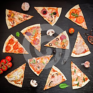 Pizza with ingredients and vegetables on black background. Flat lay, top view. Sliced pizza pattern