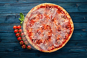 Pizza Lardon. Bacon, cherry tomatoes, sausage salami. On a wooden background.