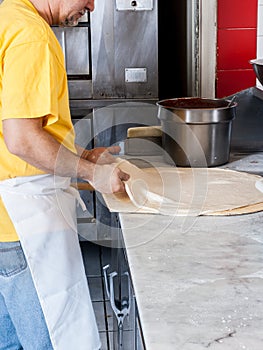 Pizza Maker stretches a Fresh Pizza dough