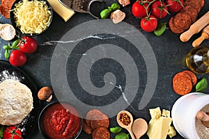 Pizza making ingredients frame against a dark background