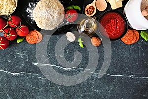 Pizza making ingredients top border against a dark background