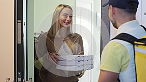 Pizza man courier is delivering an order to a woman customer. Inside shot. Food delivery concept.