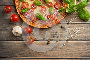 Pizza margarita on a wooden background, top view. Pizza Margarita with tomatoes, basil and Mozzarella cheese.